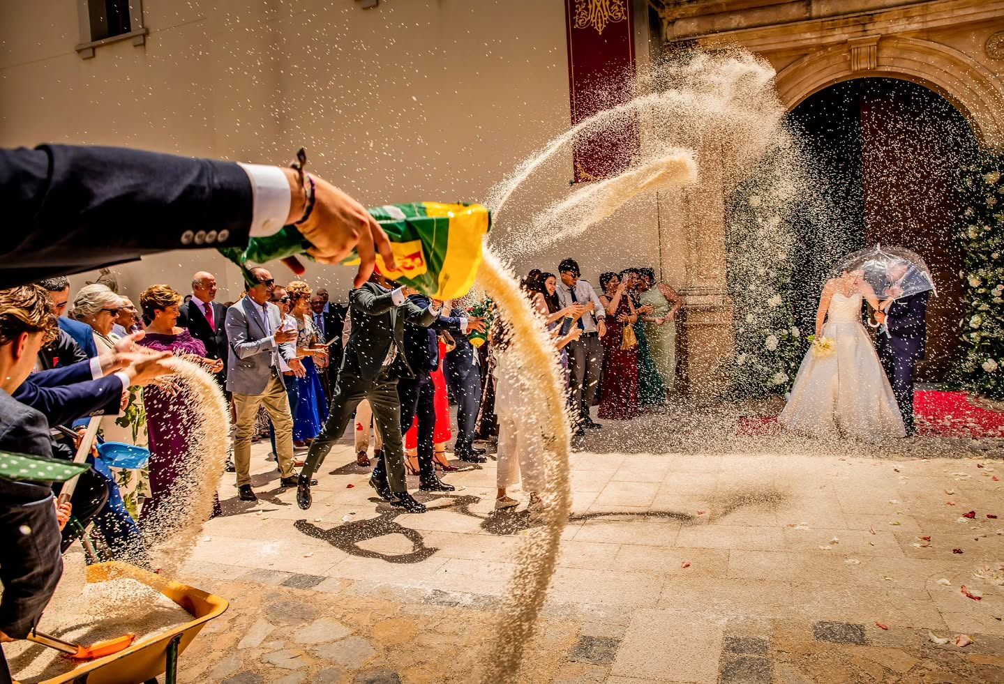 Segundo fotograma de la salida de la iglesia: el arroz cae en cascada sobre los novios